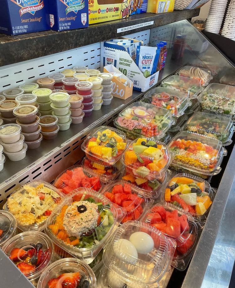 Grab and go case filled with fresh fruit cups, parfaits and prepared salads