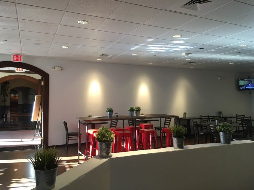 Inside Redz Urban Table with red stools, plants and cafe seating