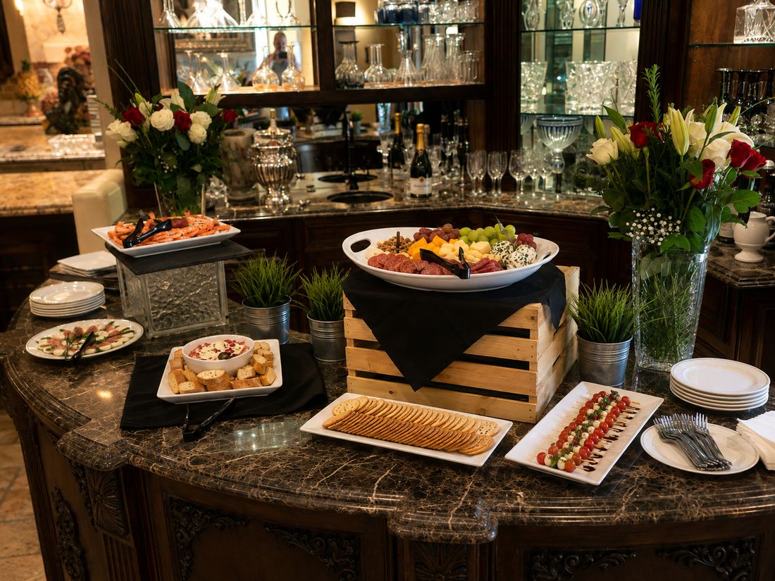 Party table with appetizer platters, a dip bowl and fresh flowers